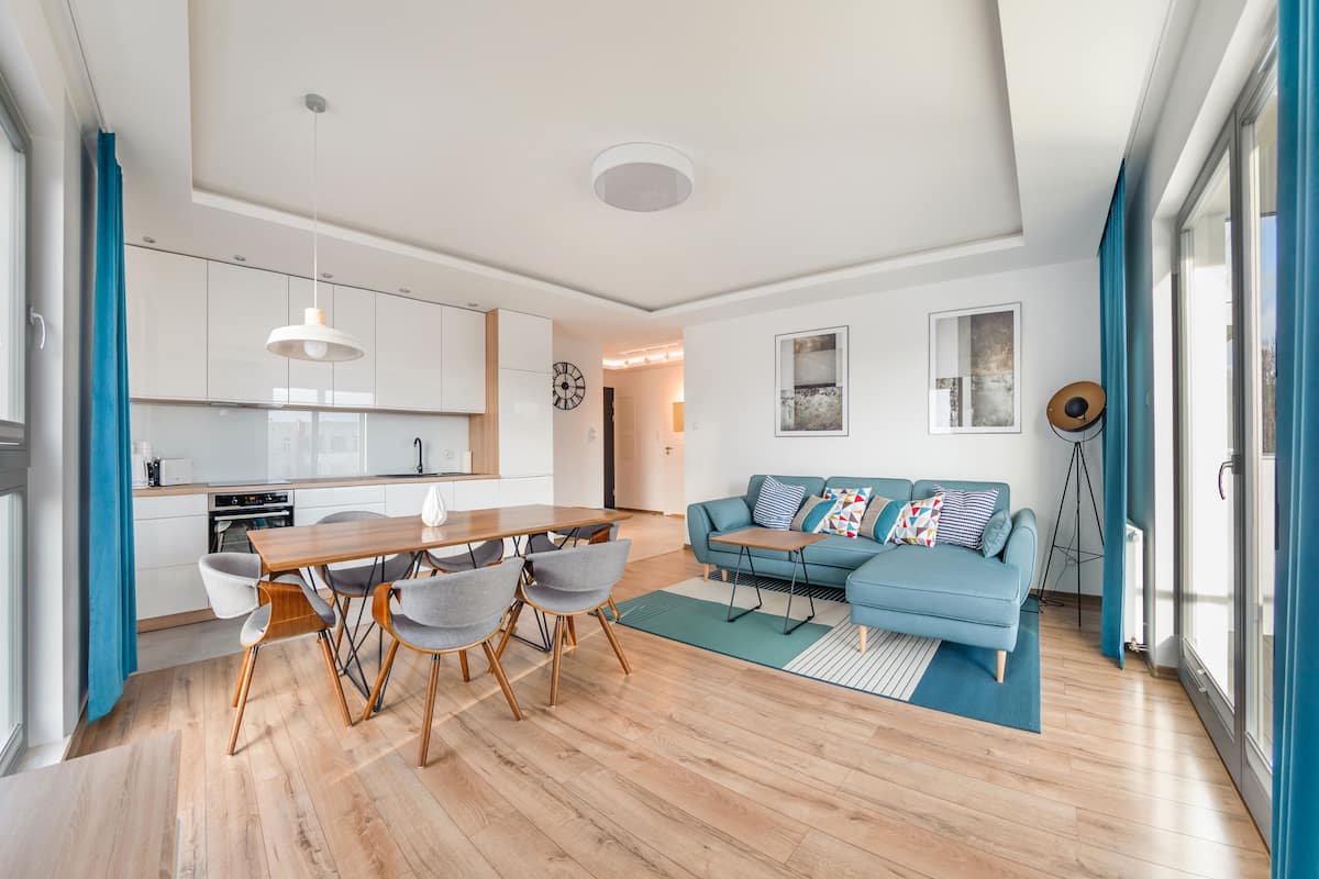 A modern apartment with a kitchen, dining area, and living room.
