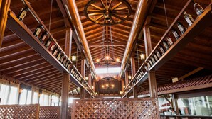 A spacious interior with high wooden ceilings, a central chandelier, and rows of wine bottles on shelves. - Aparthotel Marina Holiday Club & Spa (Pomorie)