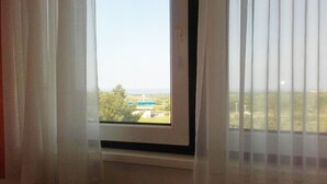 A window with a view of a building and greenery outside. - Apartments Adriana (Tar-Vabriga)