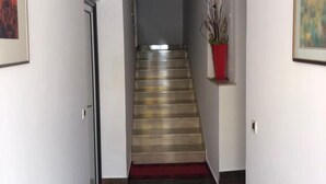 A hallway with a staircase leading to a landing. - Apartments Adriana (Tar-Vabriga)
