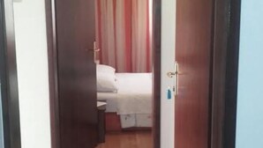 A narrow hallway leading to a bedroom with a bed and a curtain. - Apartments Adriana (Tar-Vabriga)