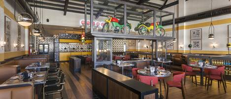 A restaurant with booths and tables, a bar area, and a display of motorcycles.