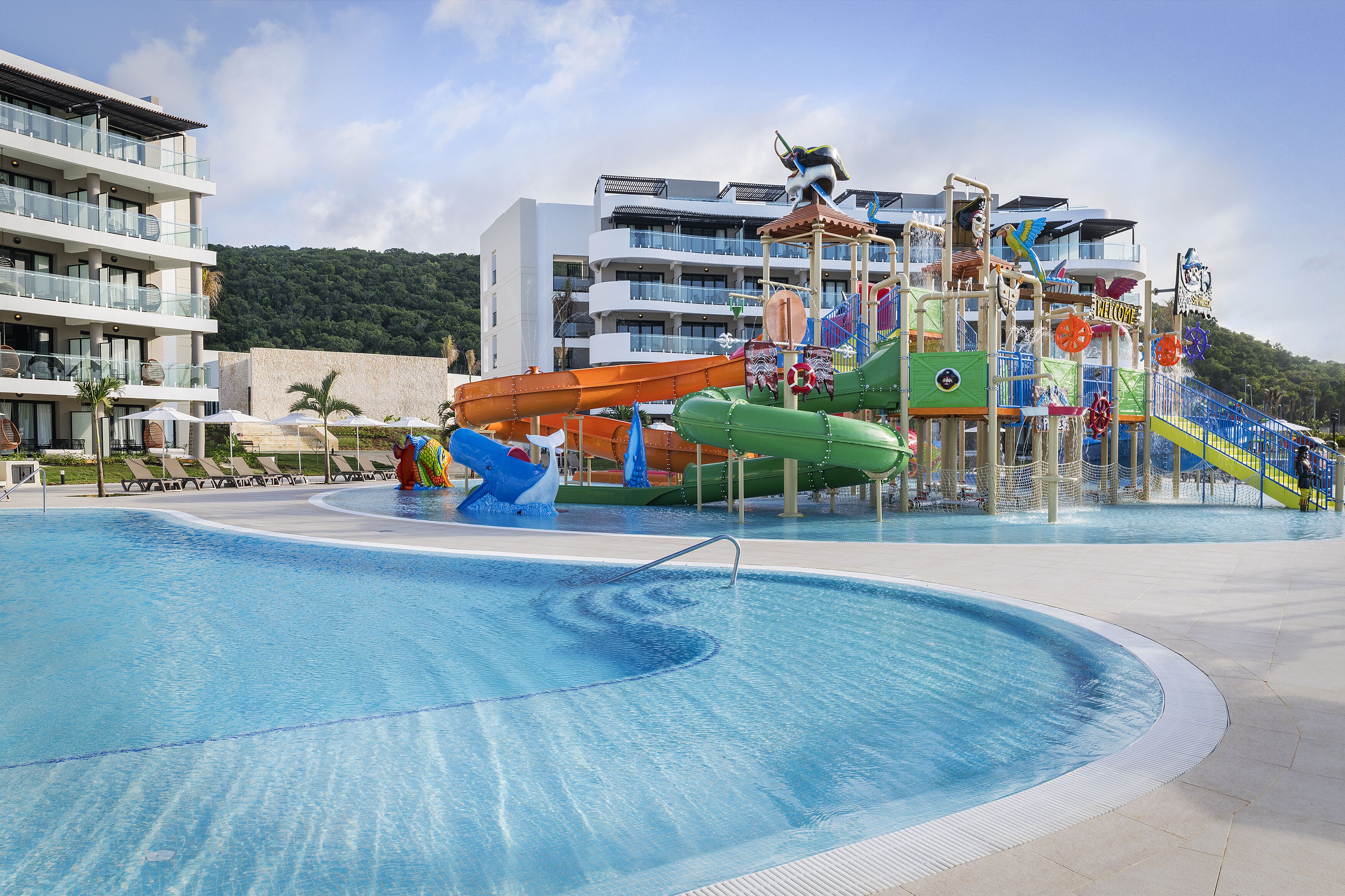 A swimming pool with a water slide and a children's play area.