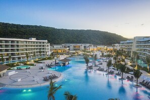 A resort with multiple swimming pools, sun loungers, and a view of a forested hill. - Ocean Coral Spring - All Inclusive (Falmouth)