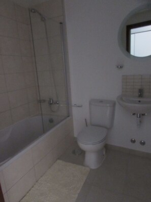 A bathroom with a bathtub, toilet, and sink.