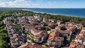 A residential area with apartment buildings, a beach, and a clear sky. - Apartamenty Sun & Snow Neptun Park (Gdansk)