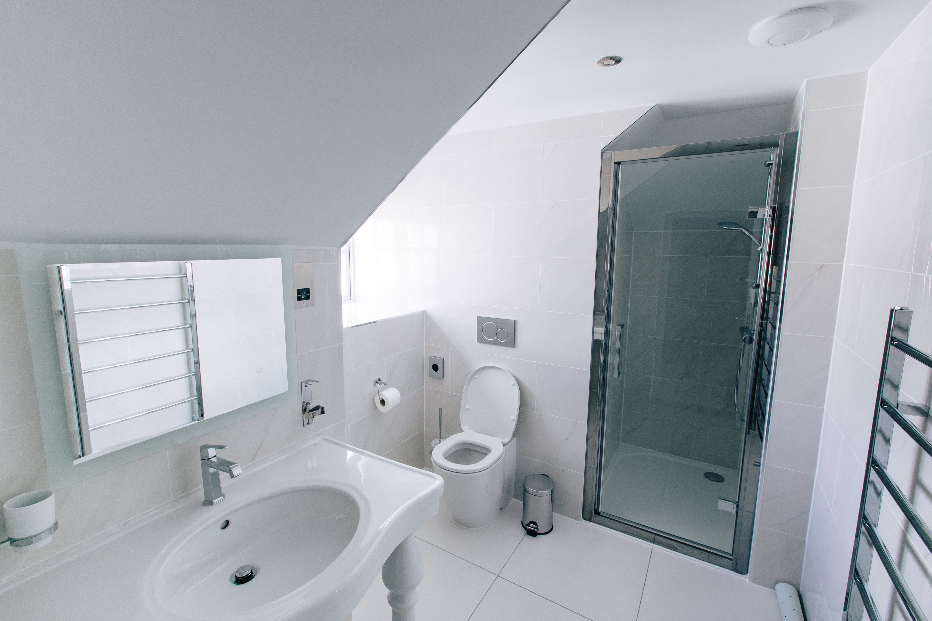 A modern bathroom with a sink, toilet, and glass-enclosed shower.