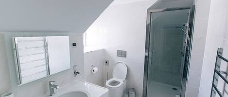 A modern bathroom with a sink, toilet, and glass-enclosed shower.