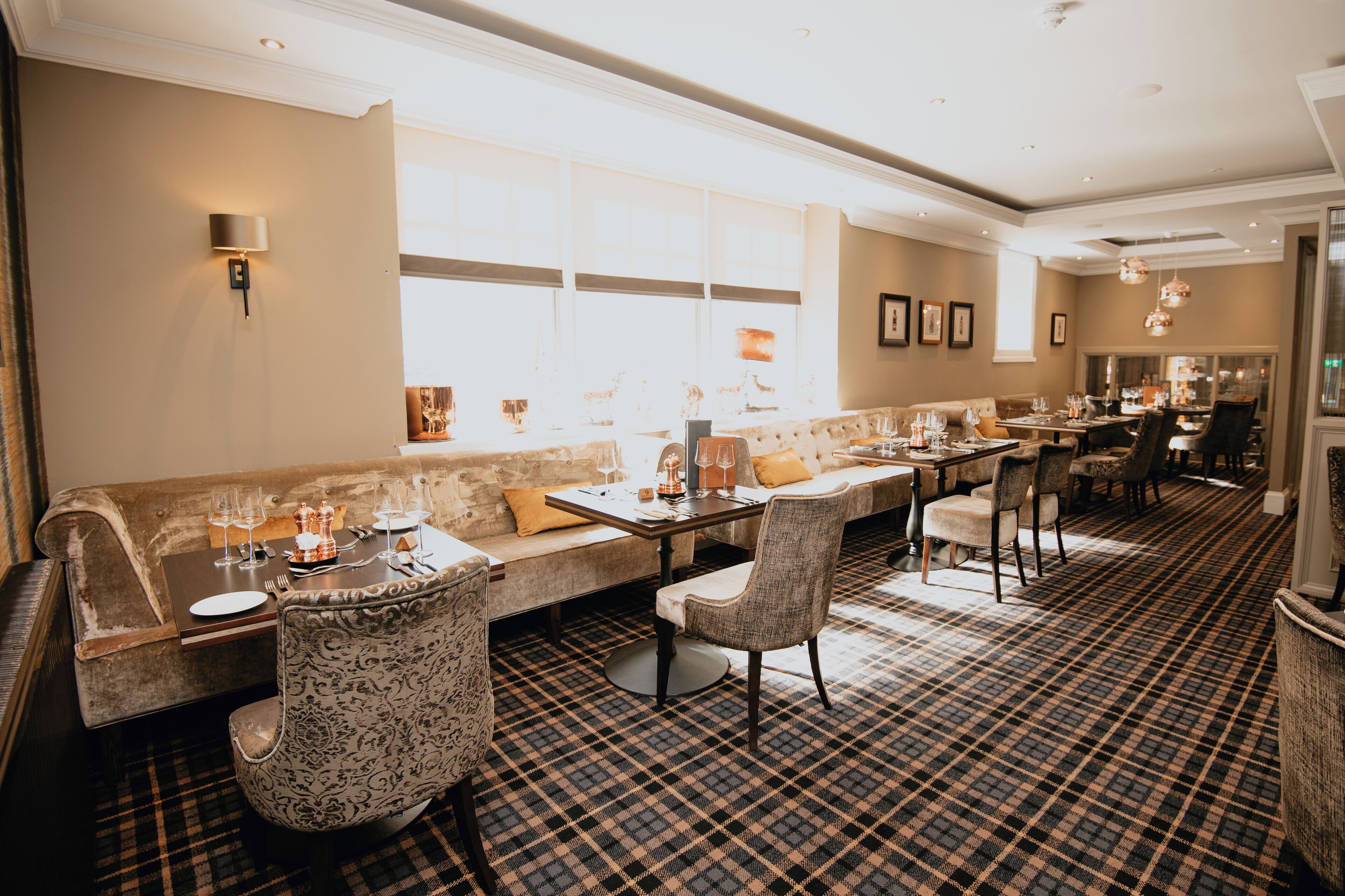 A restaurant with a checkered floor, a long counter, and a seating area with a sofa and chairs.