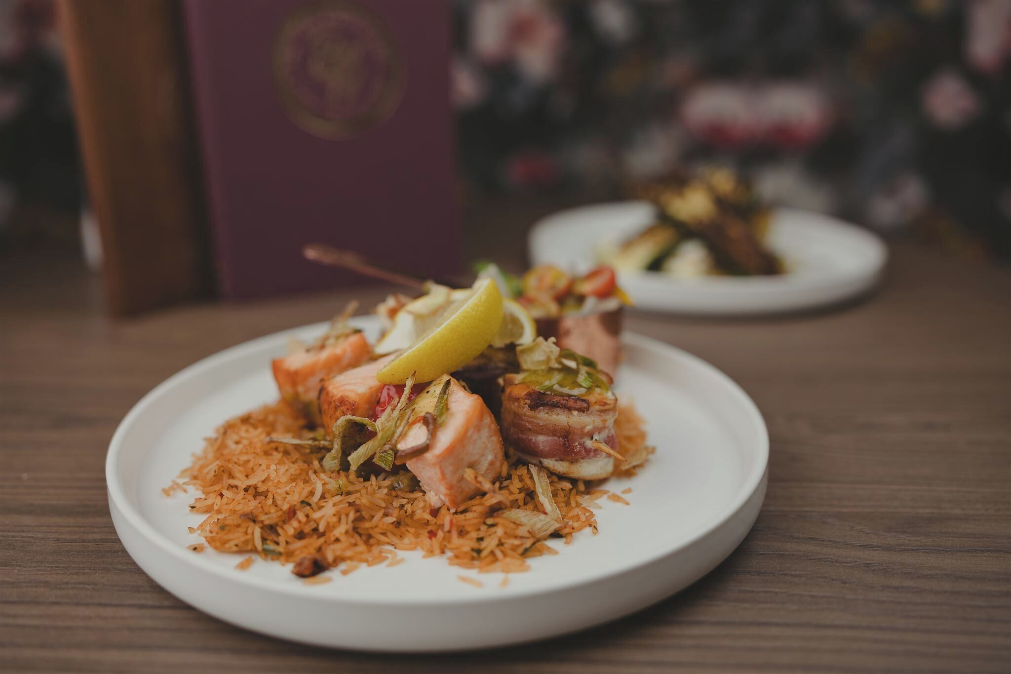 A plate of food with rice and salmon, accompanied by a lemon wedge.