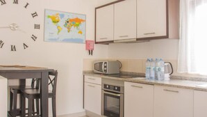 A kitchen with a world map, a microwave, and a stove.