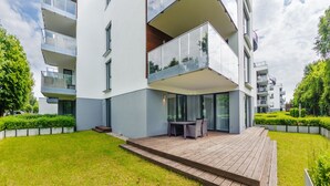 A modern apartment building with a wooden deck and outdoor seating area. - Apartamenty Sun & Snow Jelitkowska (Gdansk)