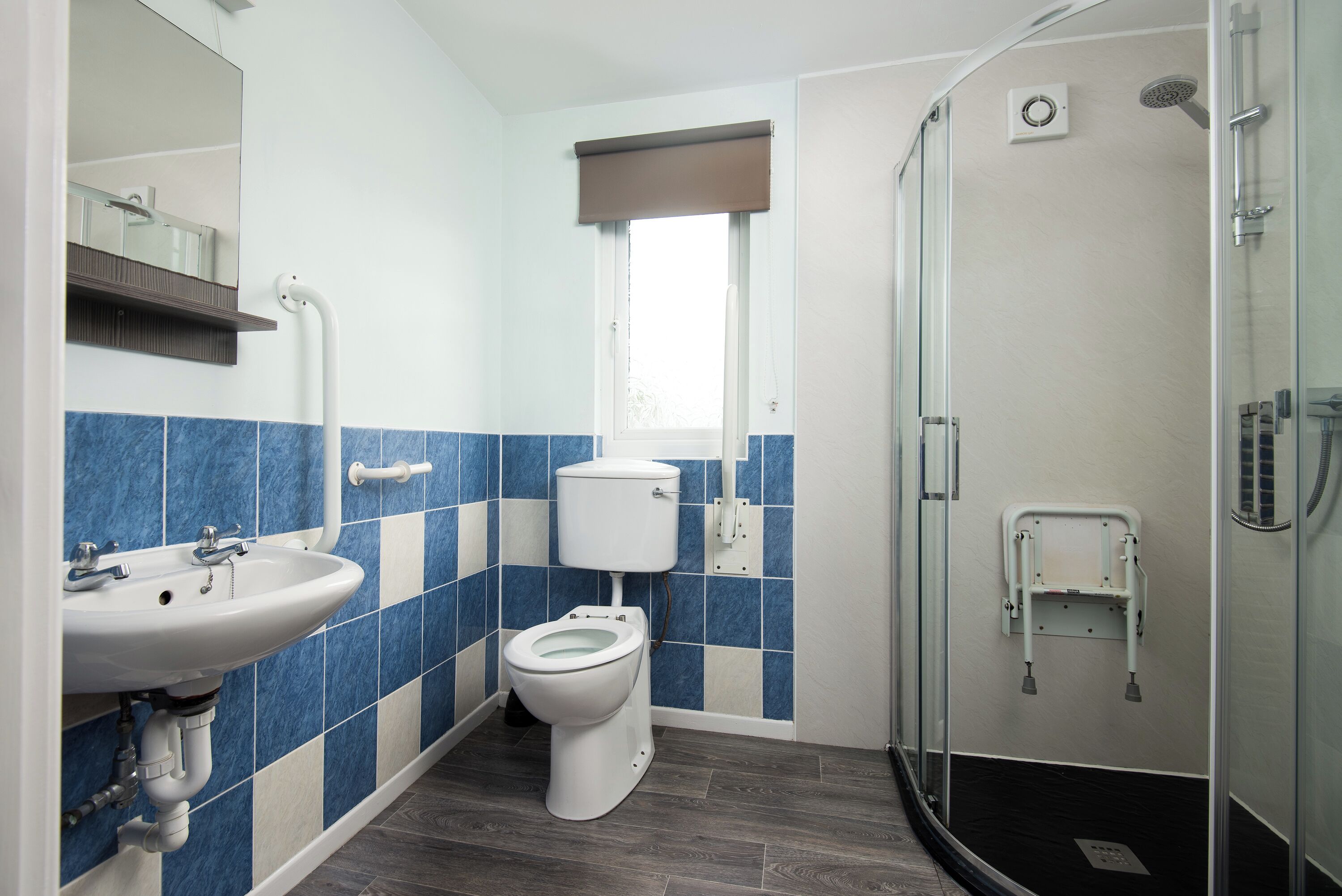 A bathroom with a sink, toilet, and a glass-enclosed shower area.