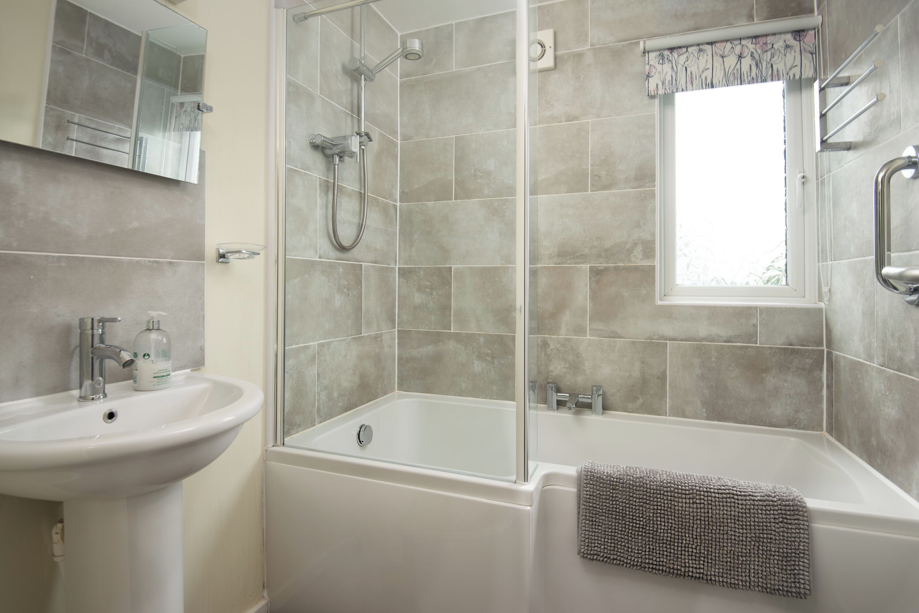 A modern bathroom with a sink, bathtub, and shower.
