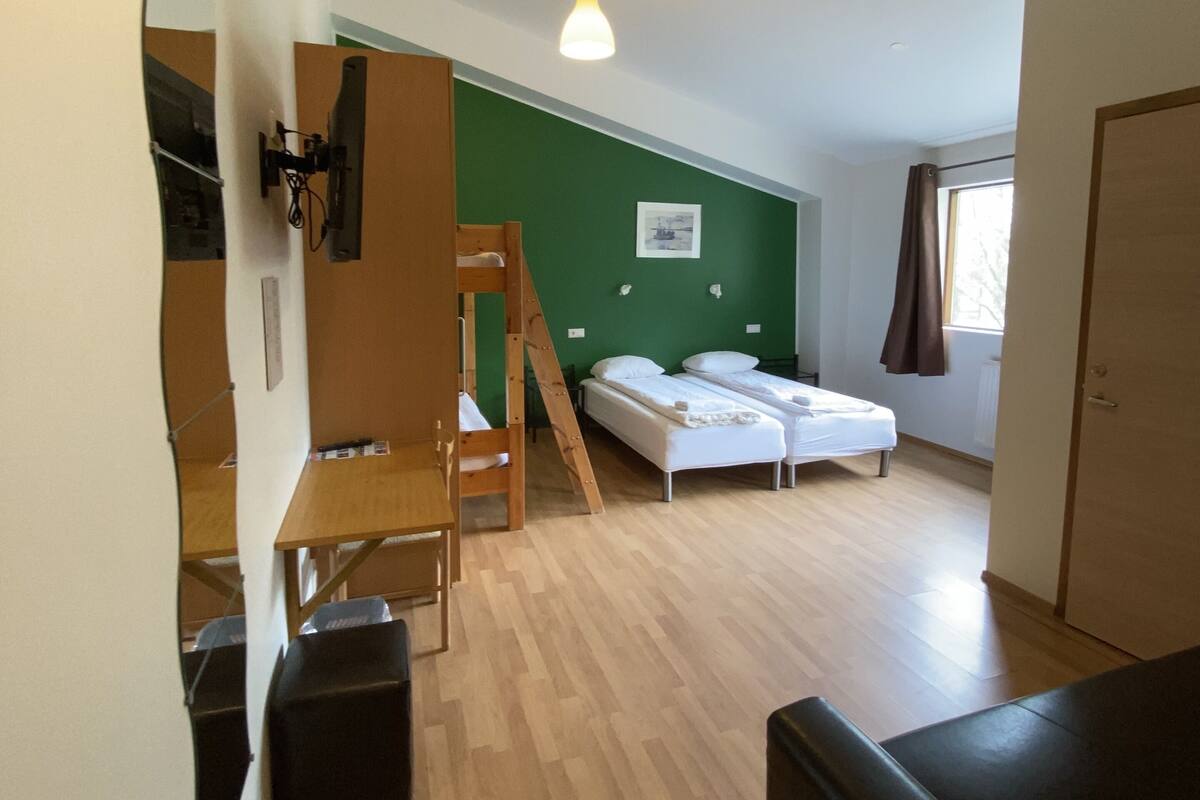 Ein kleines Zimmer mit Etagenbett, Schreibtisch und Stuhl.
