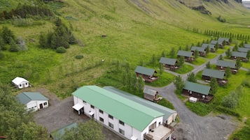 Surrounded by rolling hills and sparse vegetation, the cabins offer a peaceful retreat in a serene mountain setting.