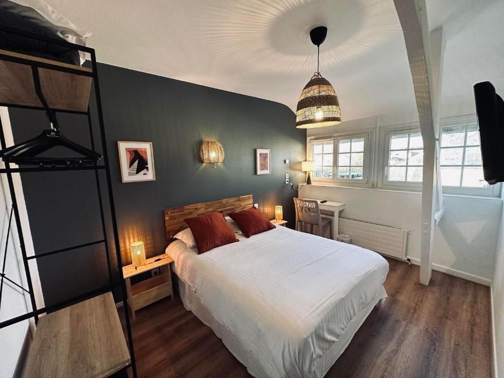Ein Schlafzimmer mit Bett, Nachttischen, einer Pendelleuchte, einem Schreibtisch und einem Stuhl.