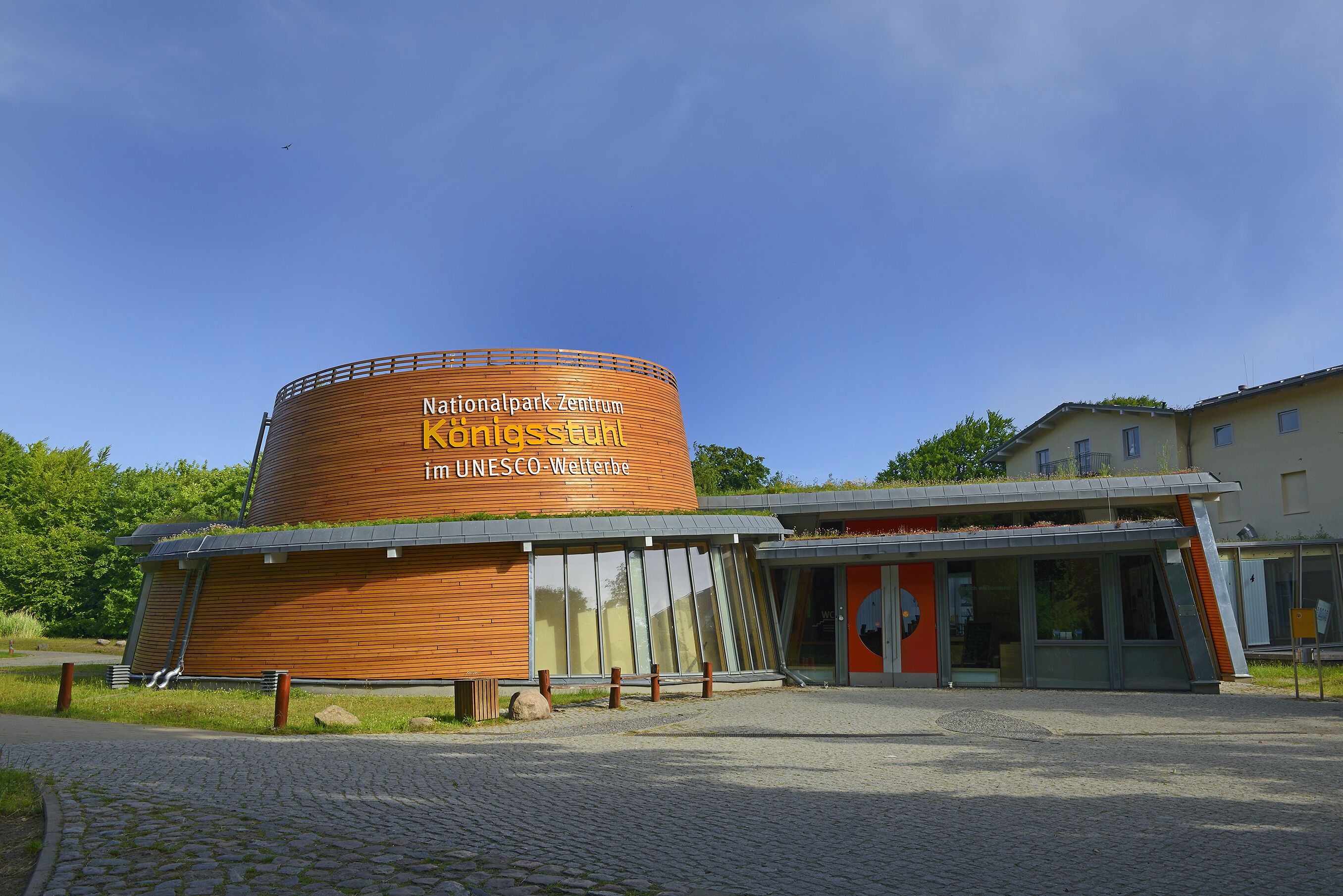 Un bâtiment moderne à la structure cylindrique, portant les inscriptions « Centre du parc national » et « Patrimoine mondial de l’UNESCO ».