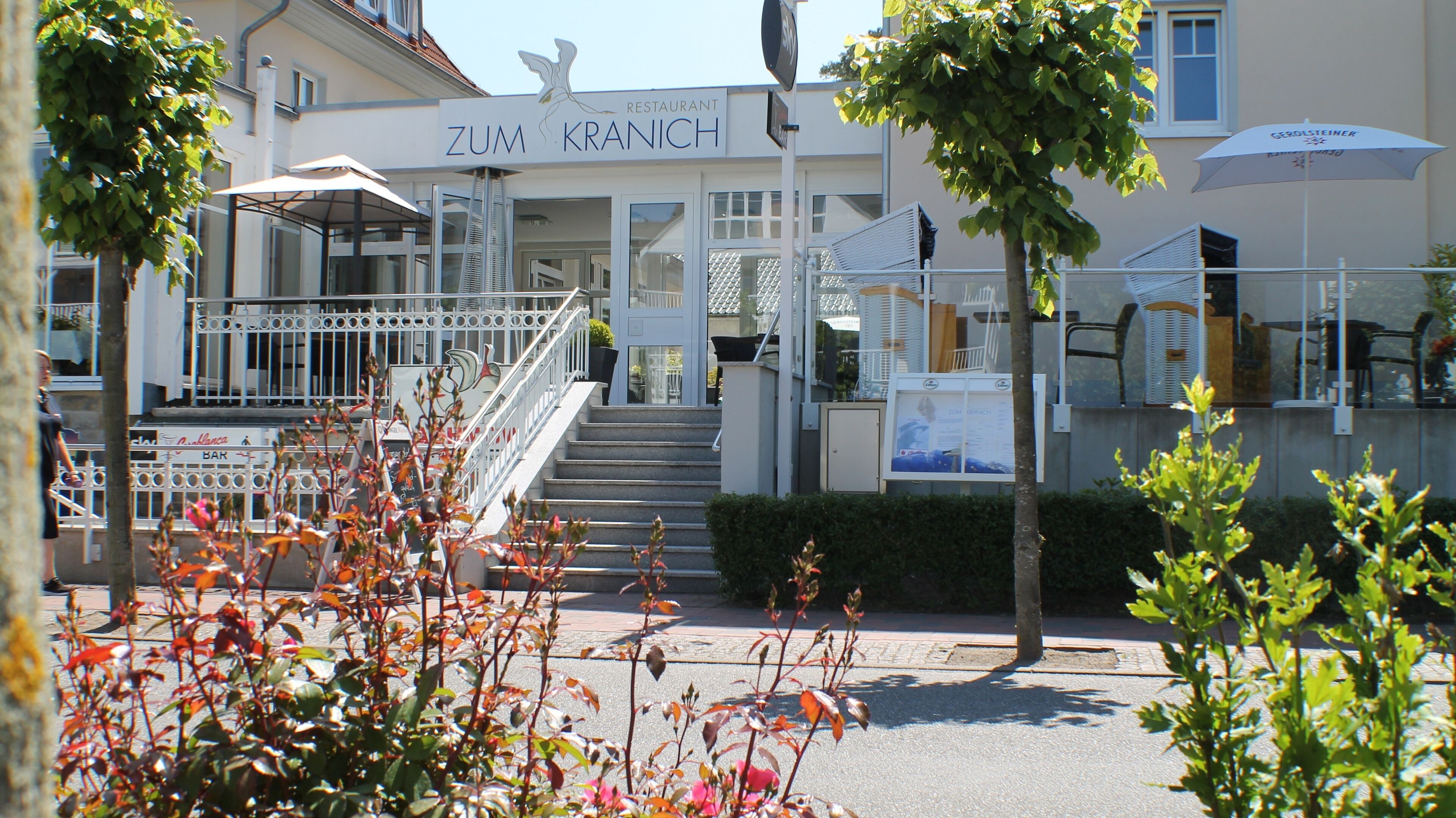 Un restaurant appelé Zum Kranich, doté d’une terrasse et d’un escalier menant à l’entrée.