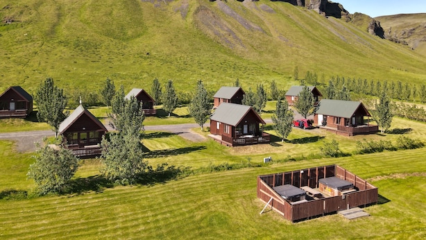 Un ensemble de chalets en bois, avec une chaîne de montagnes en arrière-plan.