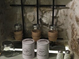 A shelf with jars labeled 'coffee' and 'sugar', and a salt and pepper shaker.