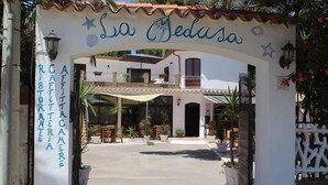 An entrance to La Jedusa with a sign indicating it is a restaurant and cafe. - La Medusa (Sant'Anna Arresi)