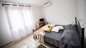 A bedroom with a bed, a desk, and a window with curtains. - La Medusa (Sant'Anna Arresi)