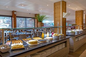 A buffet area with various food items and a plant in the background. - Sowell Residences Pra Loup (Uvernet-Fours)