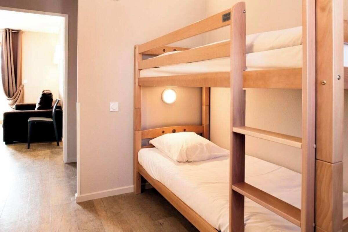 A bunk bed with a round light fixture above the middle bunk.
