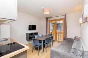 A compact living space with a kitchenette, dining area, and a sofa. - Sowell Residences Pra Loup (Uvernet-Fours)
