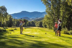 A golf course with a mountainous backdrop, trees, and a clear sky. - Sowell Residences Pra Loup (Uvernet-Fours)