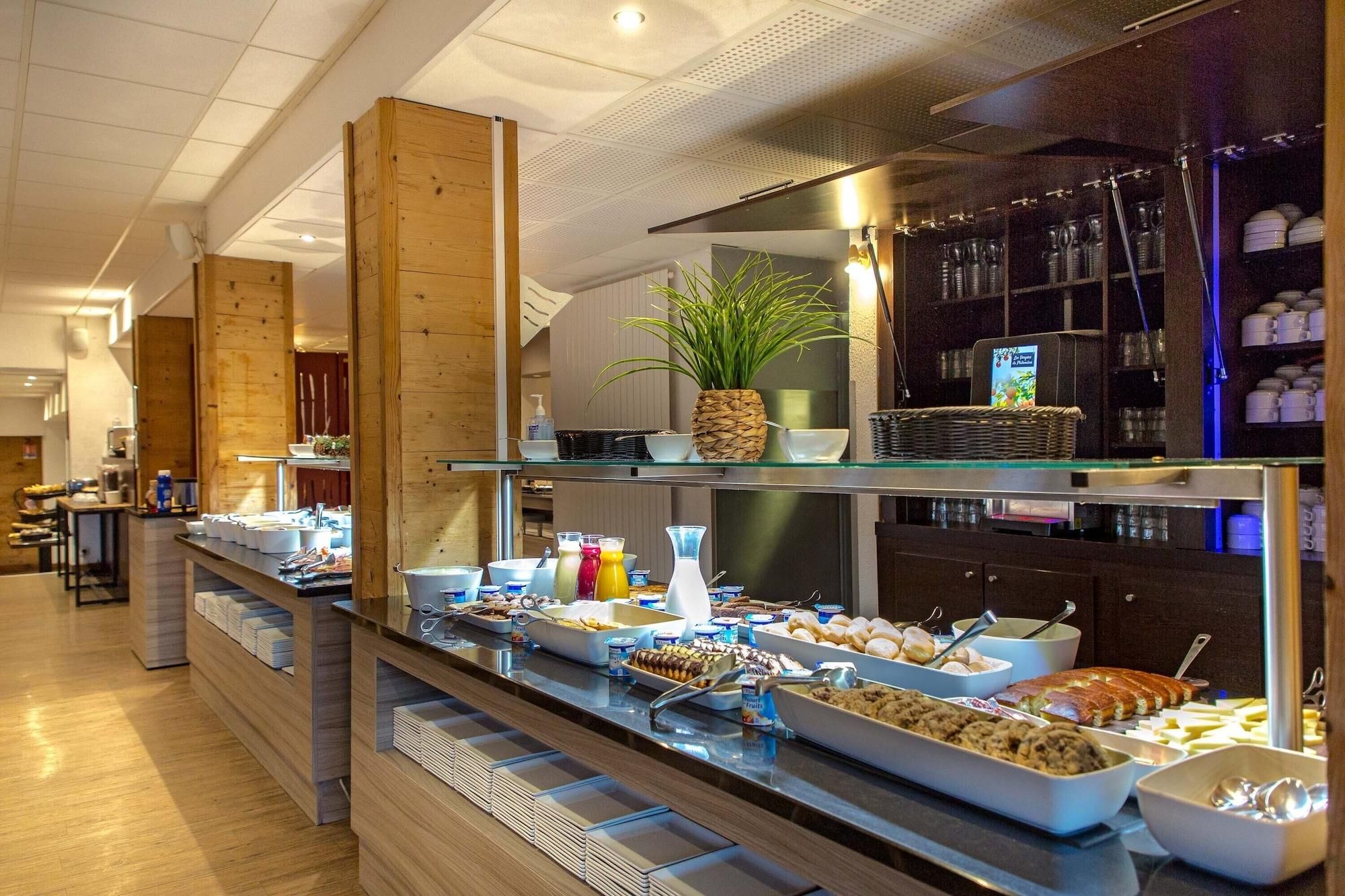 Een buffetgedeelte met diverse gerechten en een plant op een plank.