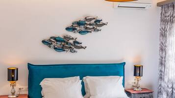 Une chambre moderne avec un grand lit, un luminaire au plafond et des œuvres d’art décoratives accrochées au mur.