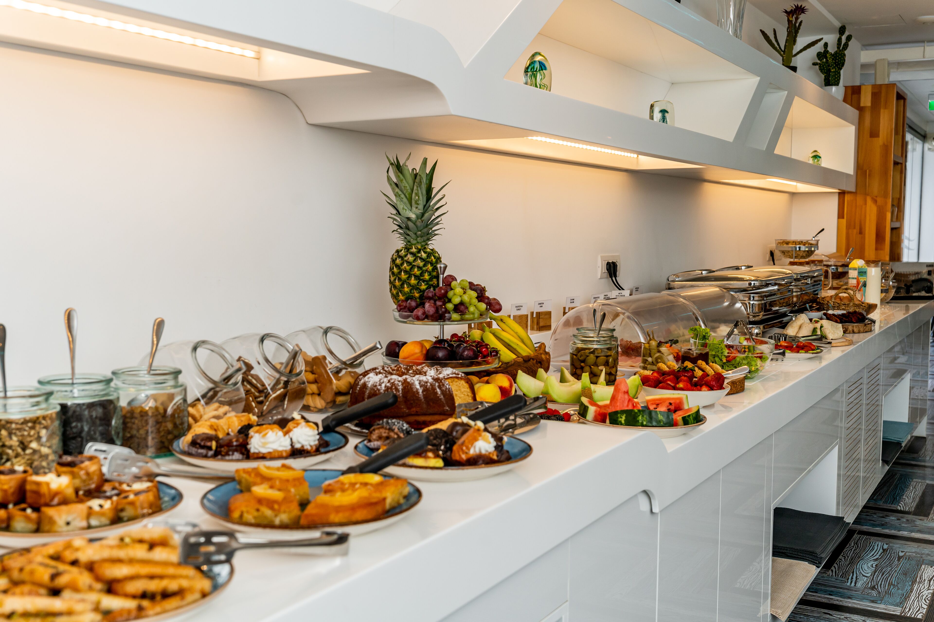 A buffet with various food items and a pineapple centerpiece.