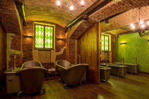 Um banheiro com banheiras de estilo vintage, porta de madeira e parede verde.