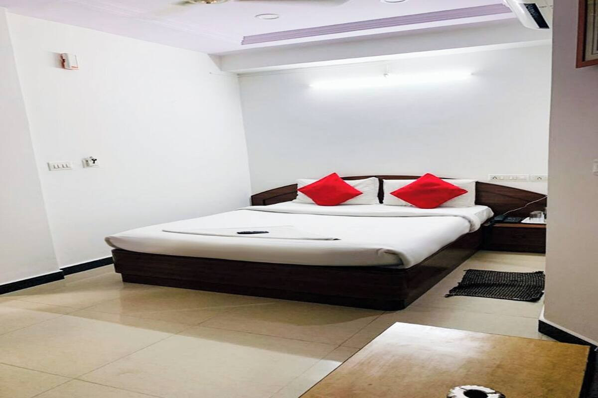 A neatly arranged bedroom with a bed, bedside table, and a small rug.