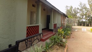 A building with a covered porch, a gated entrance, and a sign indicating no parking. - Fort Coleb Guest House (Mbarara)