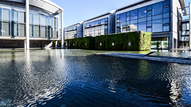 A modern building with a reflective pool in front. - Apartment T10c (Reykjavik)