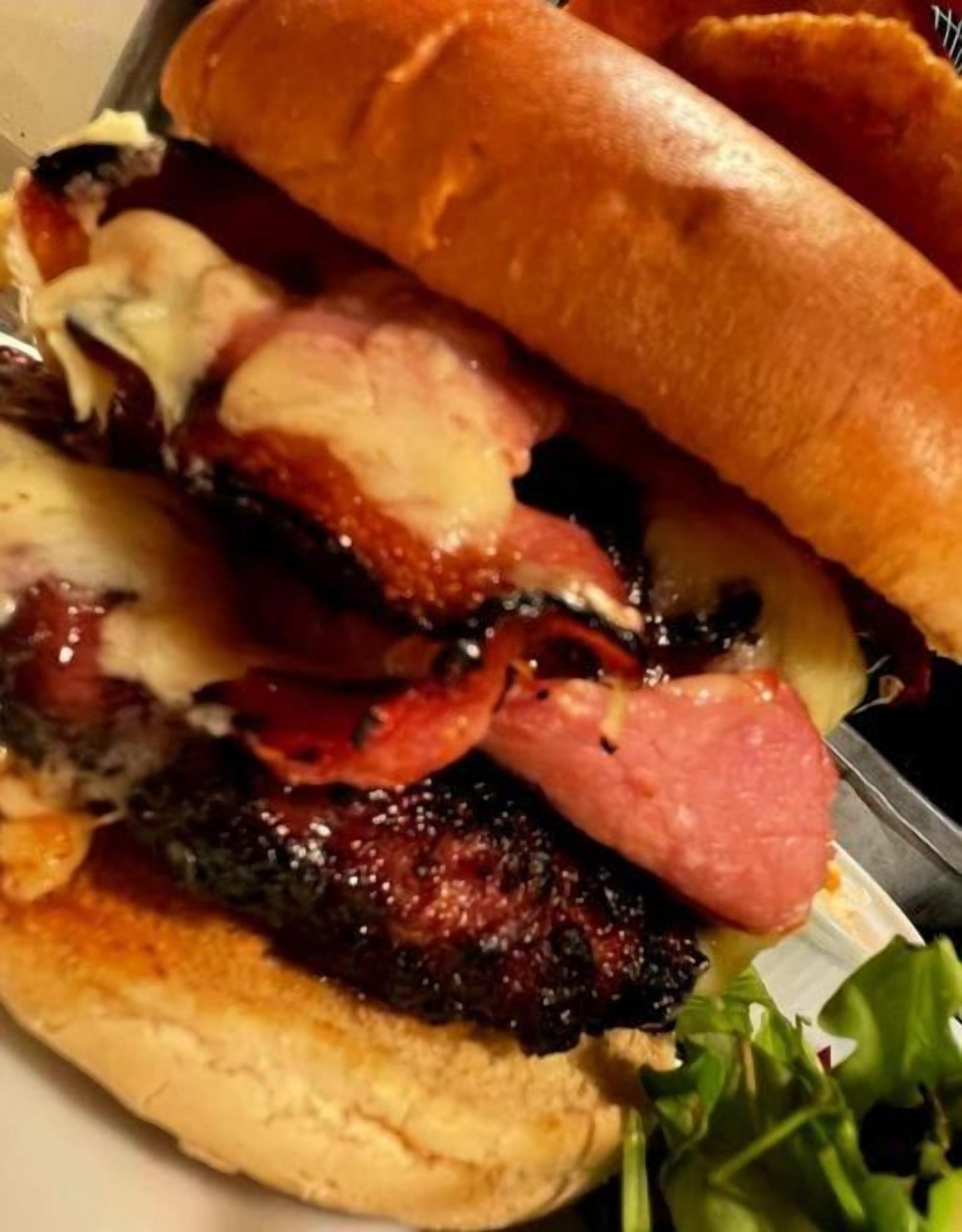 Un sándwich con diferentes carnes y queso en un pan.