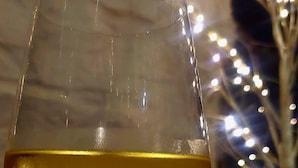 A glass of white wine with a blurred background featuring string lights. - The Black Lion Royal Hotel (Lampeter)