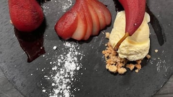 A dessert plate with pear-shaped ice cream scoops and chocolate sauce.