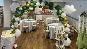 A room with round tables, chairs, and a balloon arch. - The Black Lion Royal Hotel (Lampeter)