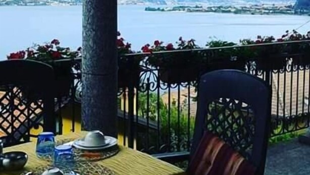 A table set for dining with a view of a lake and mountains.