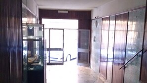 A hallway with a tiled floor leading to a door with a car visible outside. - Turist Rent Apartment Nadia (Napoli)