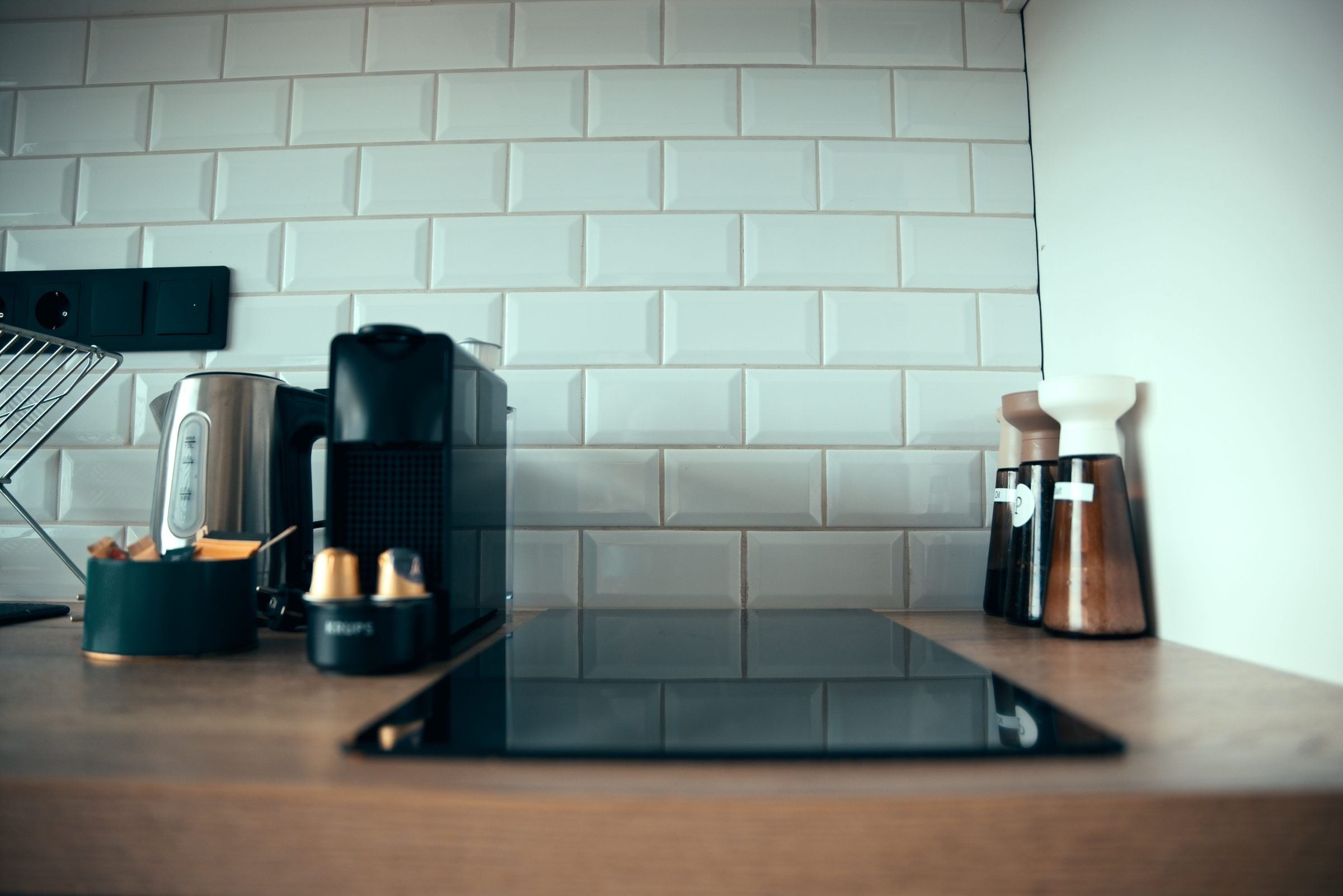 Una encimera de cocina con una cafetera, una balanza y una tableta.
