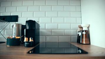 Una encimera de cocina con una cafetera, una balanza y una tableta.