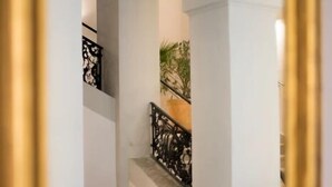 A staircase with ornate black railings and white walls. - Biohotel Schloss Kirchberg (Kirchberg an der Jagst)
