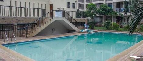 A swimming pool with a staircase leading to a building.
