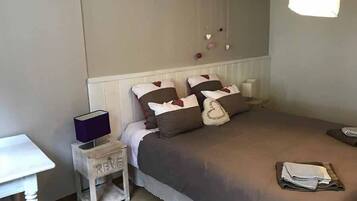 A bedroom with a bed, bedside table, and a small nightstand.