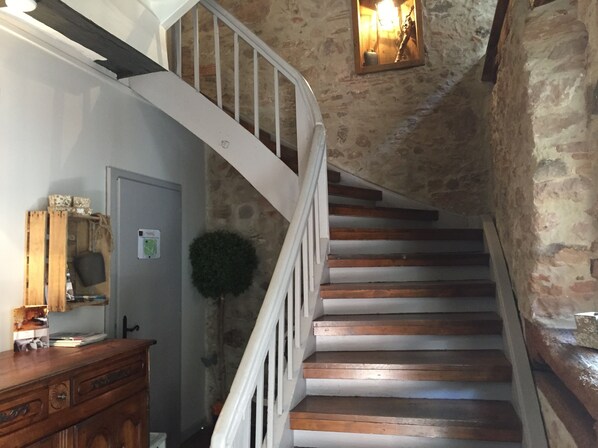 A wooden staircase with white railings leading to a landing.